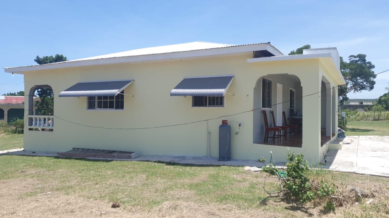 The side of the bungalow with awnings and back veranda