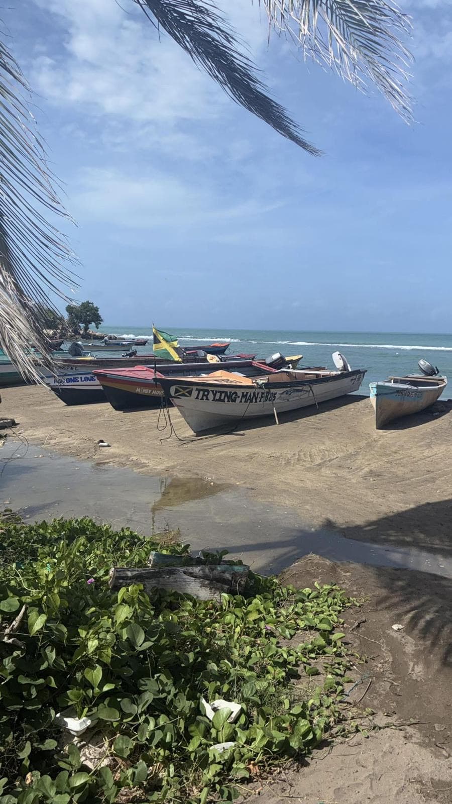 Local fishing boats on the beach, flying the Jamaican flag