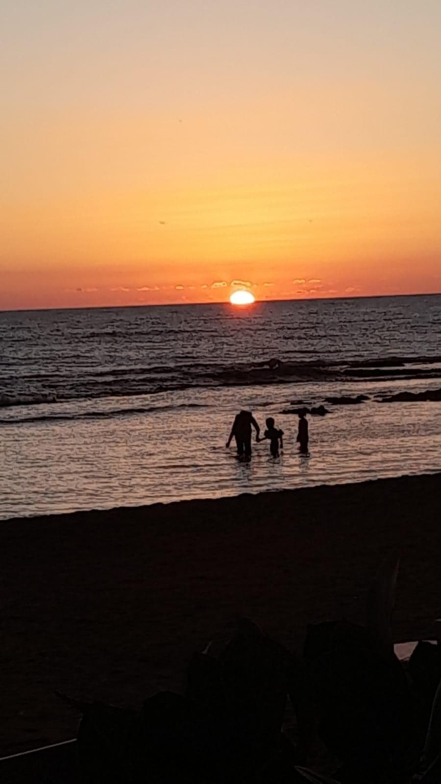 A family wading at sunset on Treasure Beach